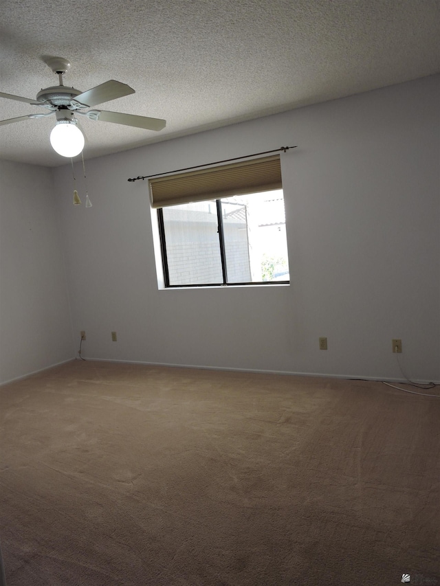 carpeted spare room with a textured ceiling and ceiling fan