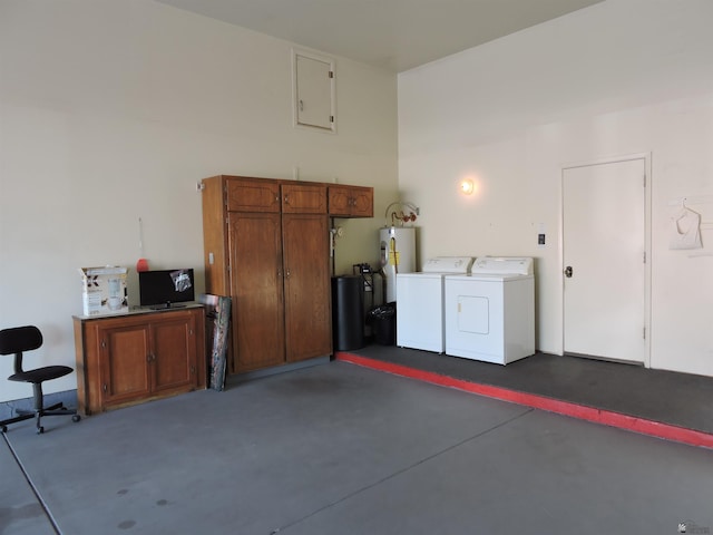 garage featuring electric water heater and washing machine and clothes dryer