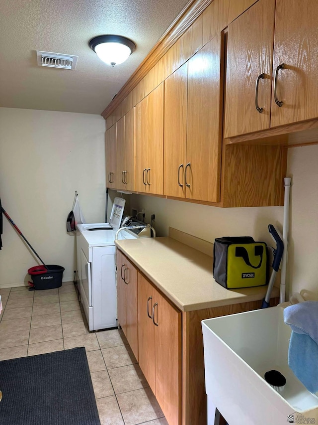 washroom featuring cabinet space, light tile patterned floors, visible vents, hookup for a washing machine, and a sink