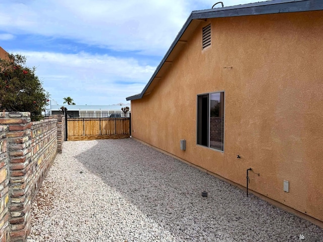 view of property exterior featuring fence, a patio, and stucco siding