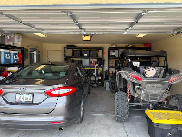 garage with strapped water heater and a garage door opener