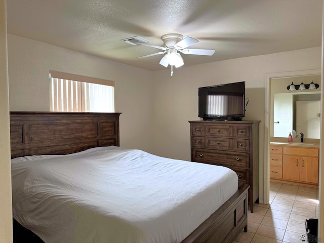 bedroom with ceiling fan, a sink, ensuite bathroom, and light tile patterned floors