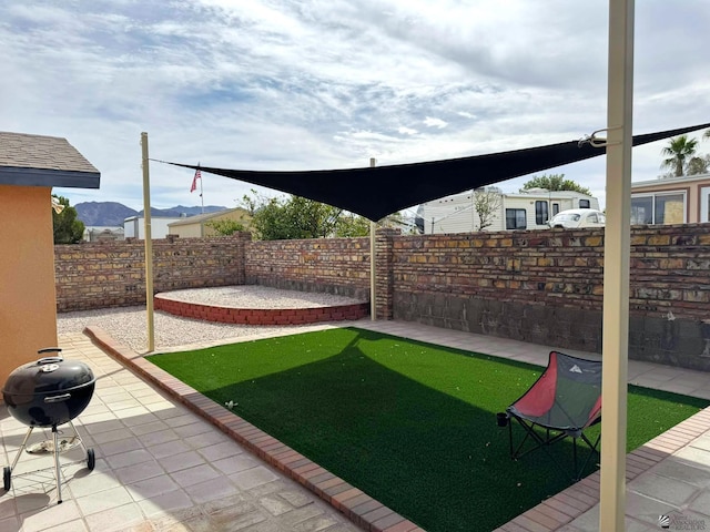 view of yard with a fenced backyard, a patio, and a mountain view