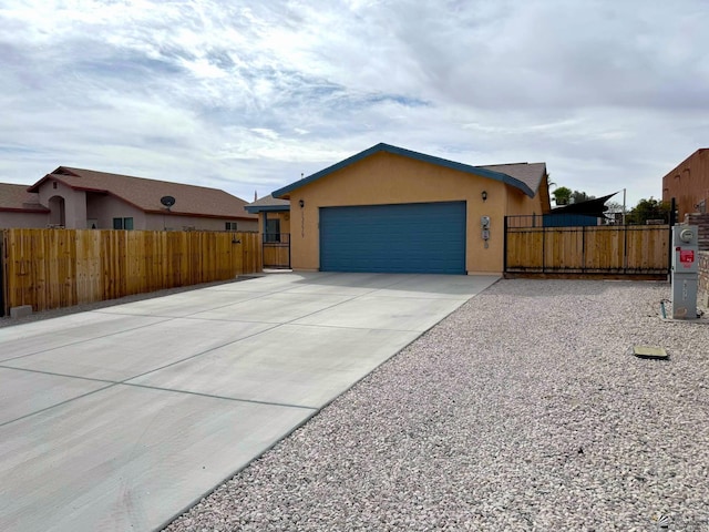 view of front facade with a fenced front yard, stucco siding, a gate, a garage, and driveway