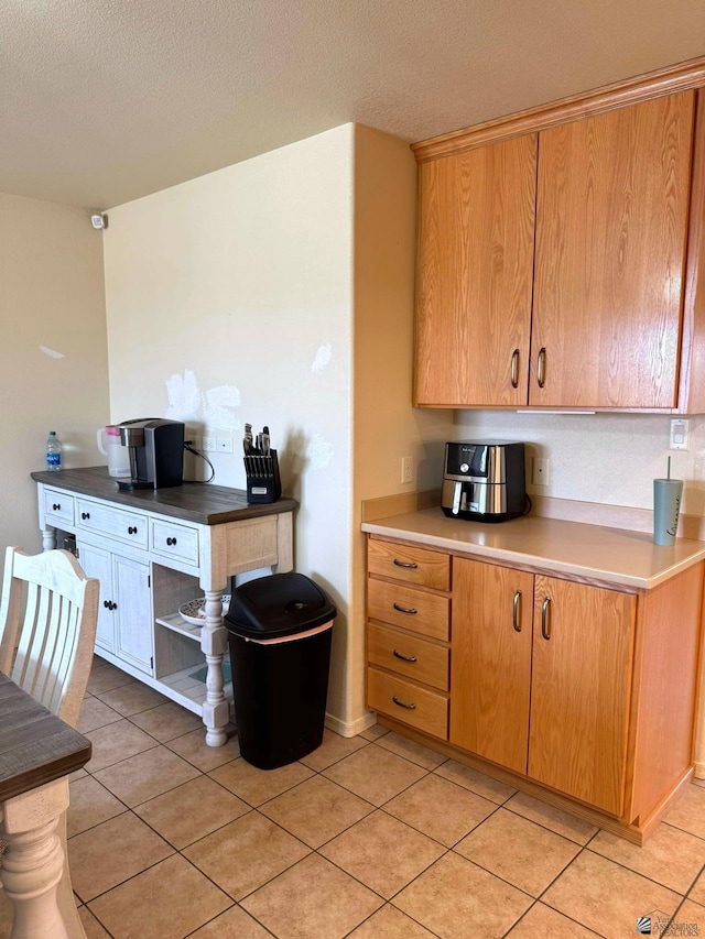 kitchen with light tile patterned floors, light countertops, and a textured ceiling