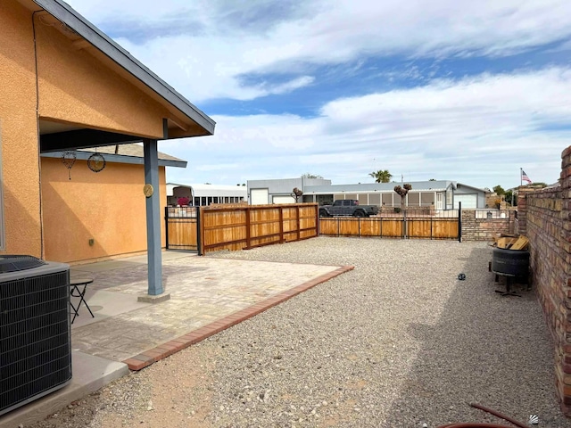 view of yard featuring fence private yard, a patio area, and central air condition unit