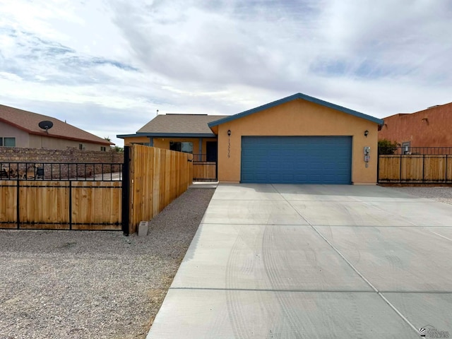 view of front of property featuring an attached garage, fence, concrete driveway, a gate, and stucco siding