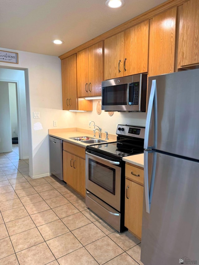 kitchen with stainless steel appliances, light countertops, a sink, and light tile patterned floors