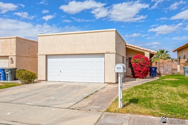 view of front of house with fence, a front yard, stucco siding, a garage, and driveway