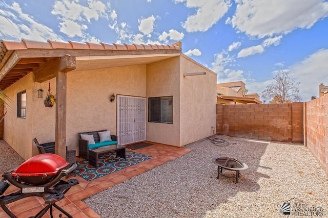 back of house featuring a patio area, a fire pit, stucco siding, and fence