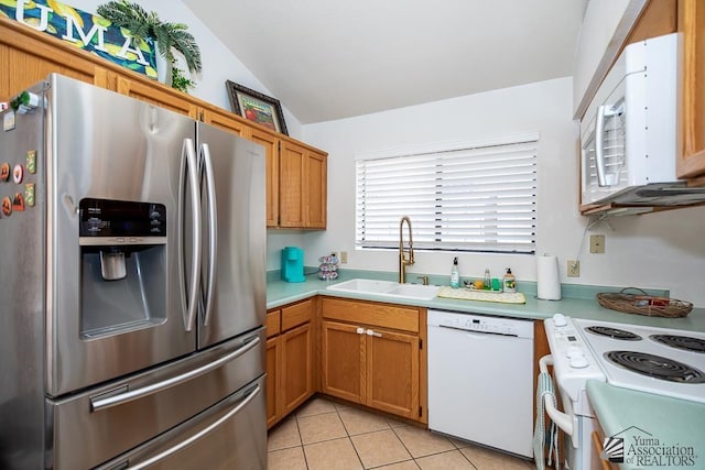 kitchen featuring white appliances, light tile patterned floors, lofted ceiling, a sink, and light countertops