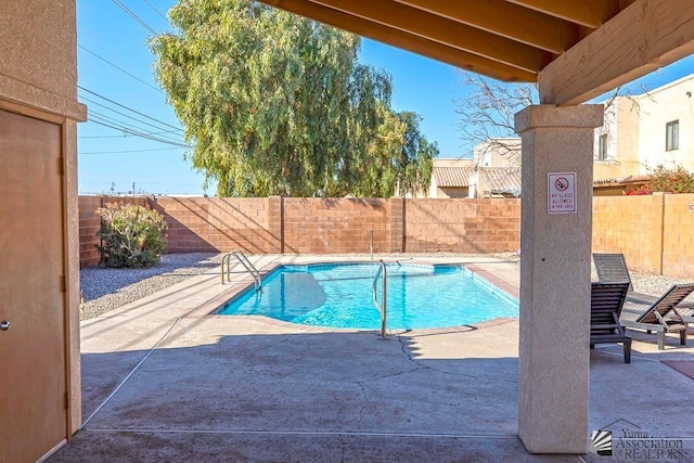 pool with a patio area and a fenced backyard