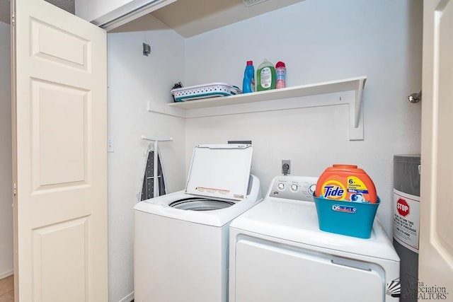 washroom featuring laundry area, separate washer and dryer, and visible vents