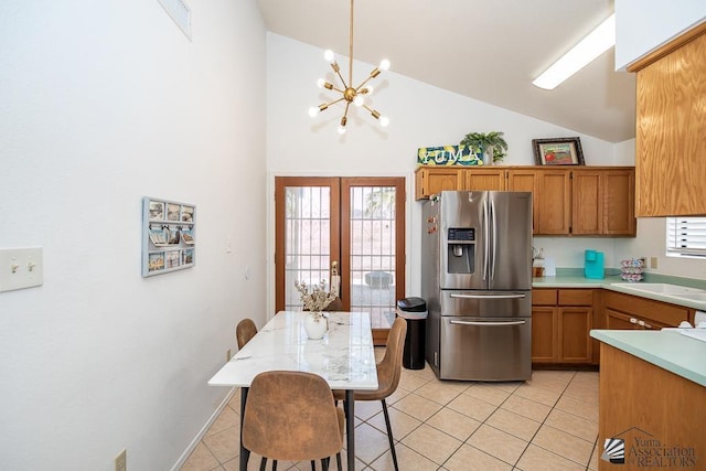 kitchen with light countertops, light tile patterned floors, french doors, stainless steel refrigerator with ice dispenser, and a sink