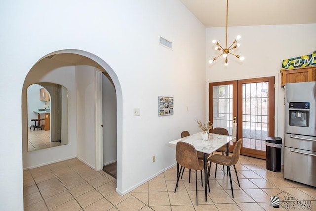 dining area featuring visible vents, light tile patterned flooring, french doors, and arched walkways