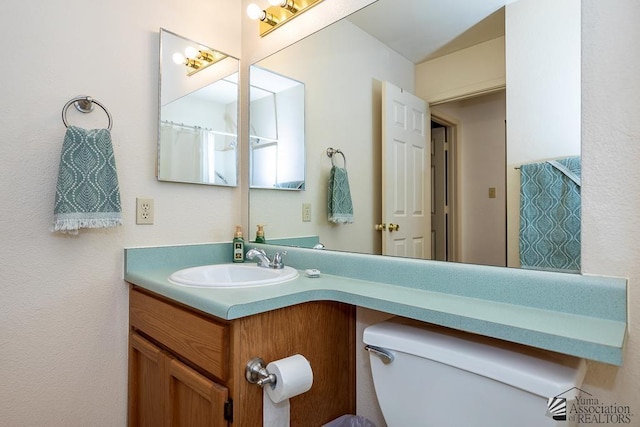 bathroom featuring toilet and vanity