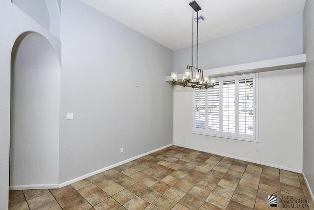 spare room with a chandelier