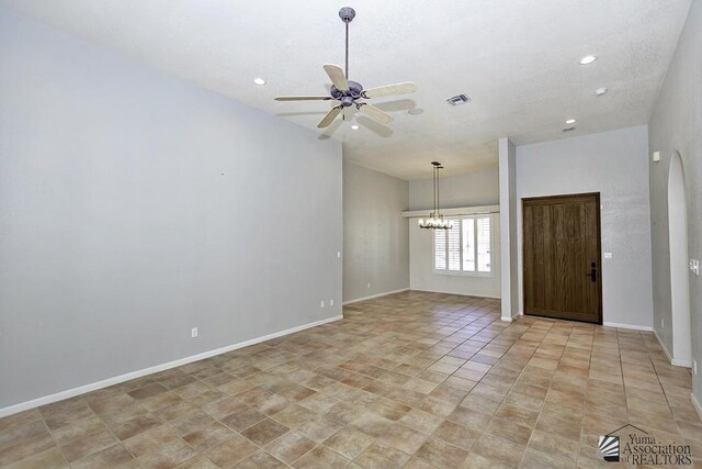 unfurnished room with ceiling fan with notable chandelier