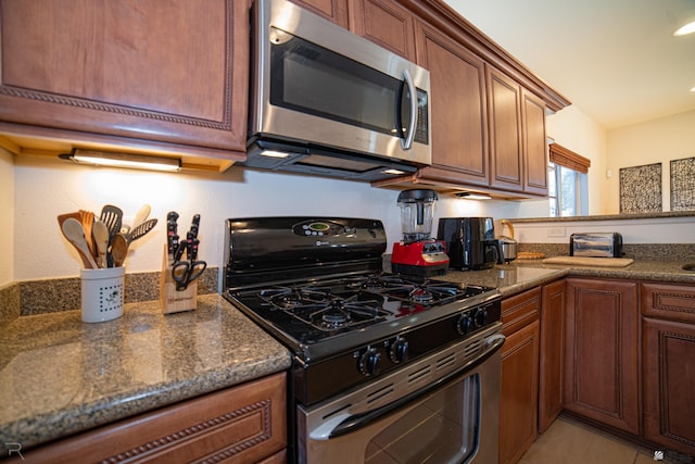 kitchen with gas stove and dark stone counters