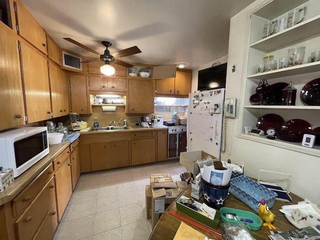 kitchen featuring white appliances, sink, ceiling fan, light tile patterned floors, and extractor fan