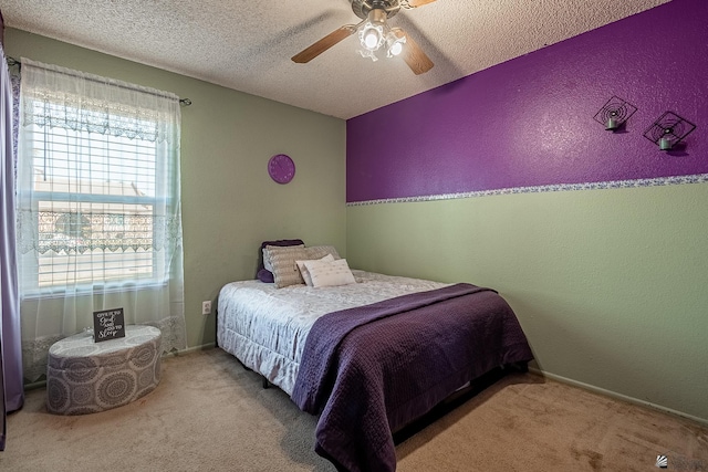 bedroom featuring light carpet, a textured wall, a textured ceiling, and ceiling fan