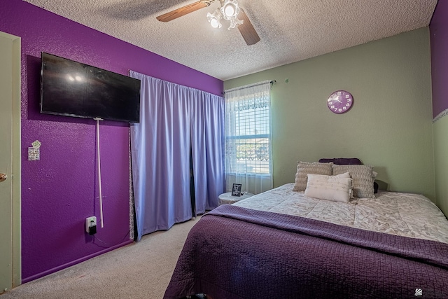 bedroom with carpet, a ceiling fan, a textured ceiling, and a textured wall