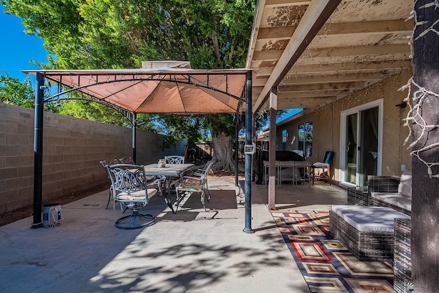 view of patio with a fenced backyard, outdoor dining area, and a gazebo