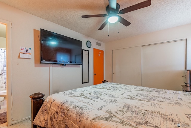 bedroom featuring ceiling fan, a closet, visible vents, and a textured ceiling