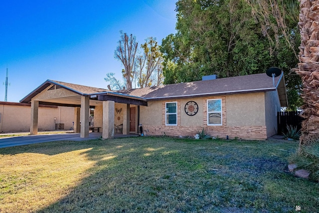 single story home featuring cooling unit, a carport, and a front lawn