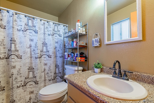 full bathroom with a textured wall, a shower with shower curtain, vanity, and toilet