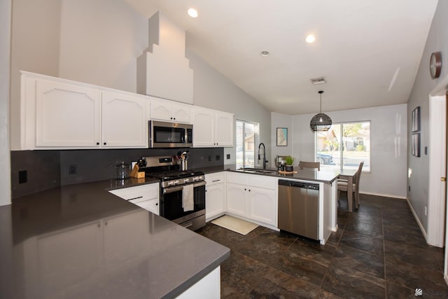 kitchen featuring white cabinetry, dark countertops, a peninsula, and stainless steel appliances