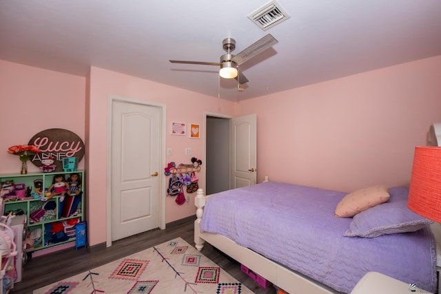 bedroom with ceiling fan, visible vents, and wood finished floors