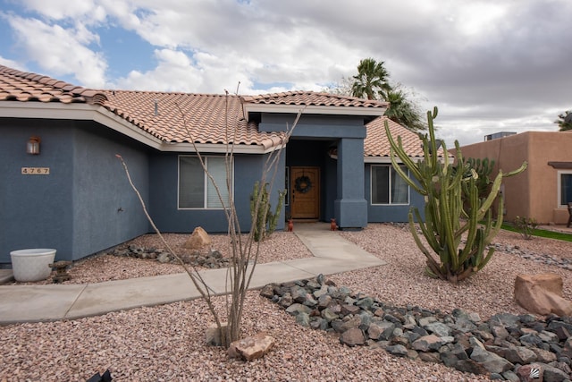 view of front of house with a tile roof and stucco siding