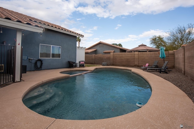 view of swimming pool with an in ground hot tub, a fenced backyard, a fenced in pool, and a patio