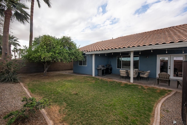 view of yard featuring a patio, french doors, and a fenced backyard