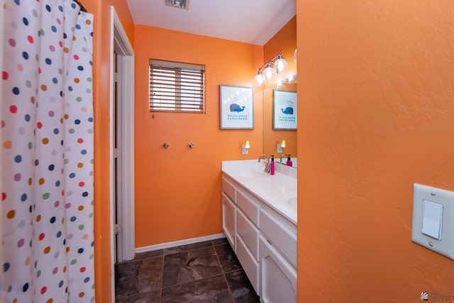 full bath featuring visible vents, a sink, a shower with shower curtain, double vanity, and baseboards