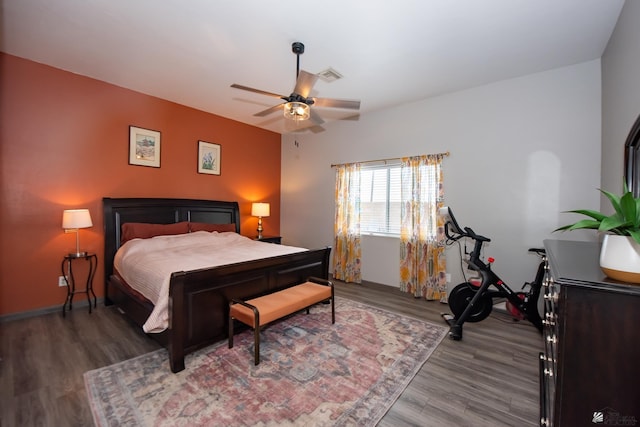 bedroom featuring a ceiling fan, wood finished floors, and visible vents