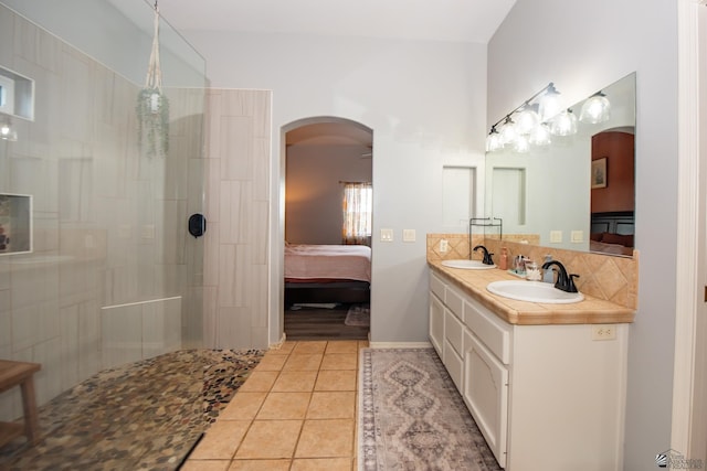 ensuite bathroom with tile patterned flooring, ensuite bath, walk in shower, and a sink