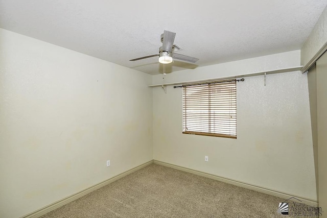 empty room with carpet floors, a textured ceiling, baseboards, and a ceiling fan