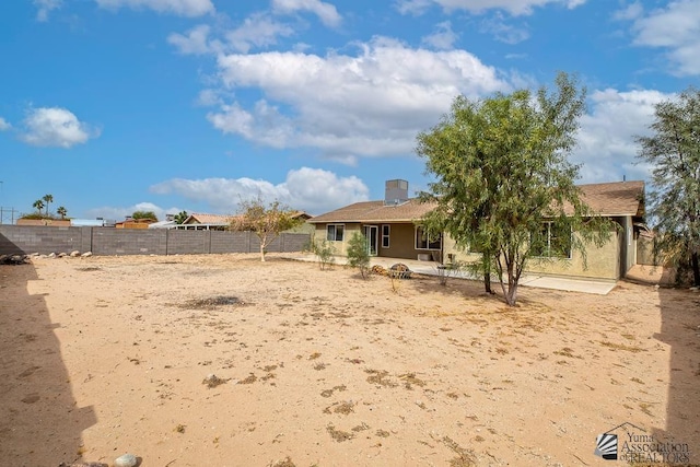 view of front of house with stucco siding, a fenced backyard, and a patio