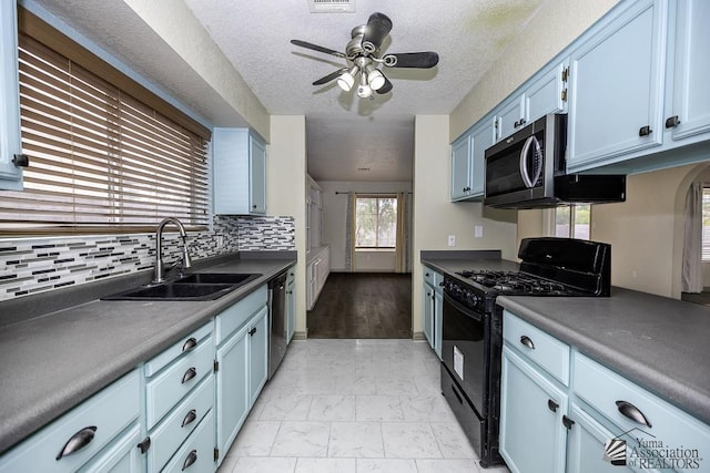 kitchen featuring blue cabinets, a sink, marble finish floor, appliances with stainless steel finishes, and tasteful backsplash