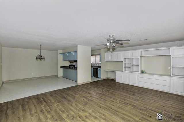 kitchen featuring dark wood-style flooring, open shelves, white cabinets, dishwasher, and ceiling fan with notable chandelier