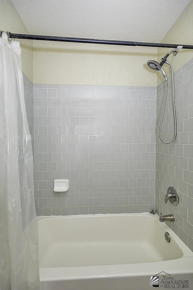 full bathroom with shower / tub combo with curtain and a textured ceiling