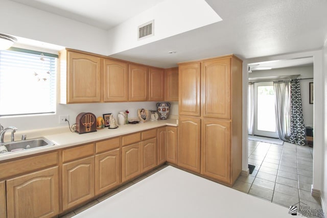 kitchen featuring light tile patterned floors and sink