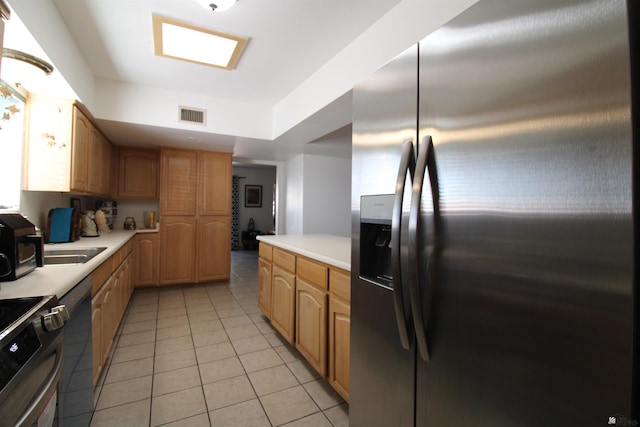 kitchen featuring stainless steel appliances and light tile patterned flooring