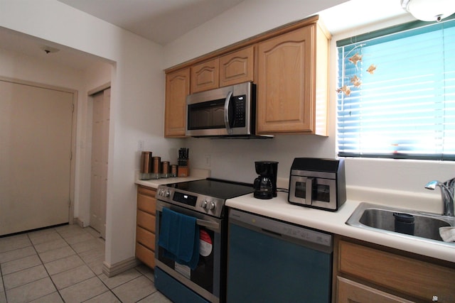 kitchen with light tile patterned flooring, appliances with stainless steel finishes, and sink