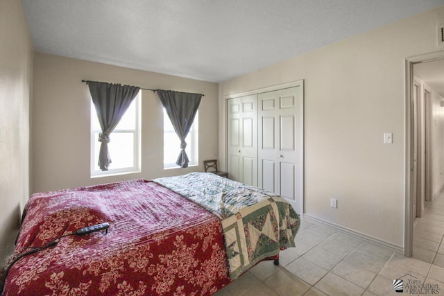 bedroom with light tile patterned flooring and a closet