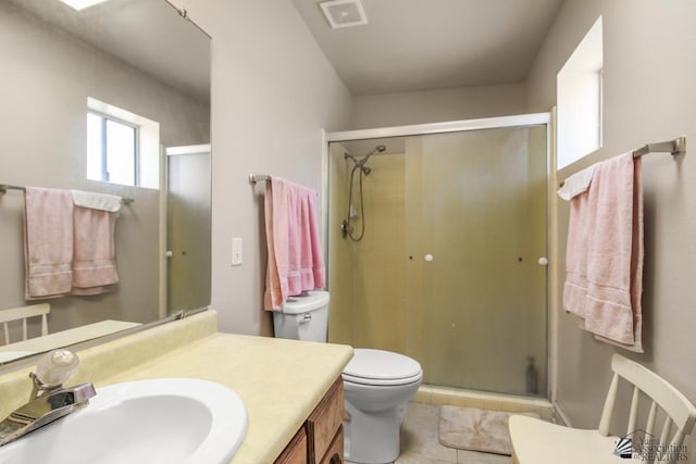 bathroom with tile patterned flooring, vanity, an enclosed shower, and toilet