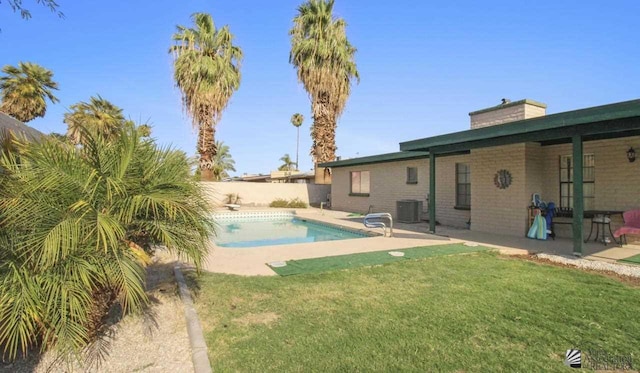 view of pool with a yard, a patio, and central air condition unit