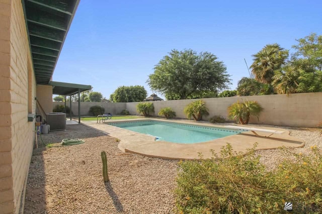 view of swimming pool featuring a diving board, central AC, and a patio area